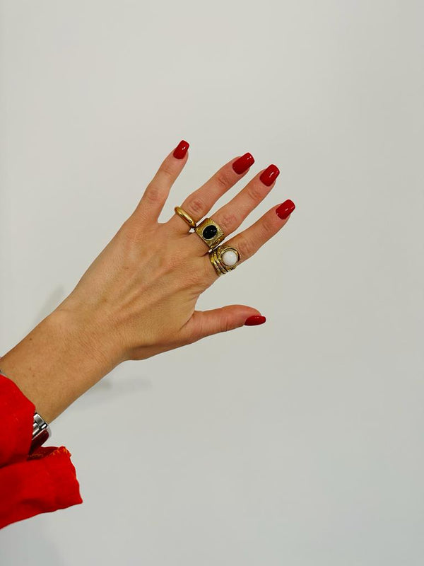 Ring mit goldenem Hintergrund und weißem Stein