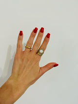 Ring mit goldenem Hintergrund und weißem Stein